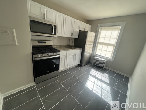 A kitchen with black appliances and white cabinets.