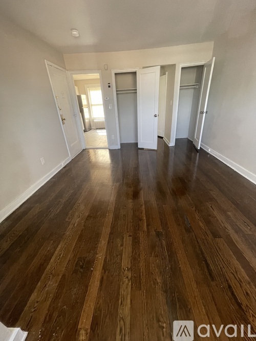 A room with wooden flooring and white walls.