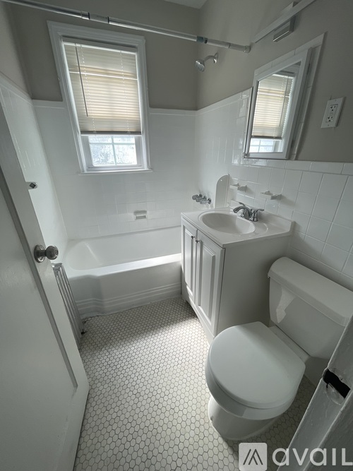 A white bathroom with a toilet, sink, and bathtub.