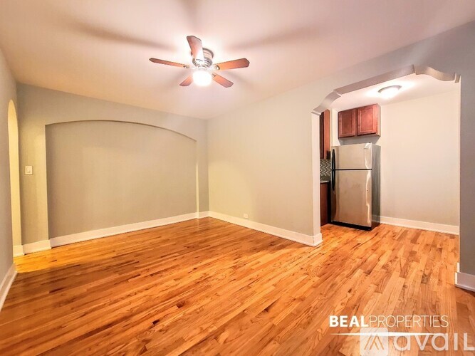 A room with a ceiling fan and wooden flooring.
