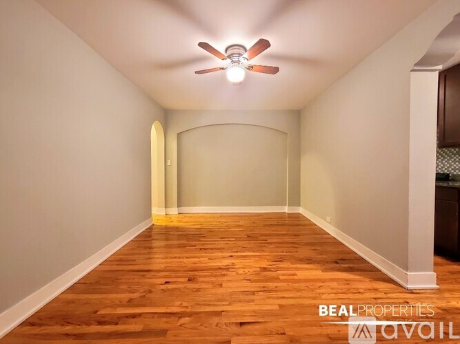 A room with wooden floors and a ceiling fan.