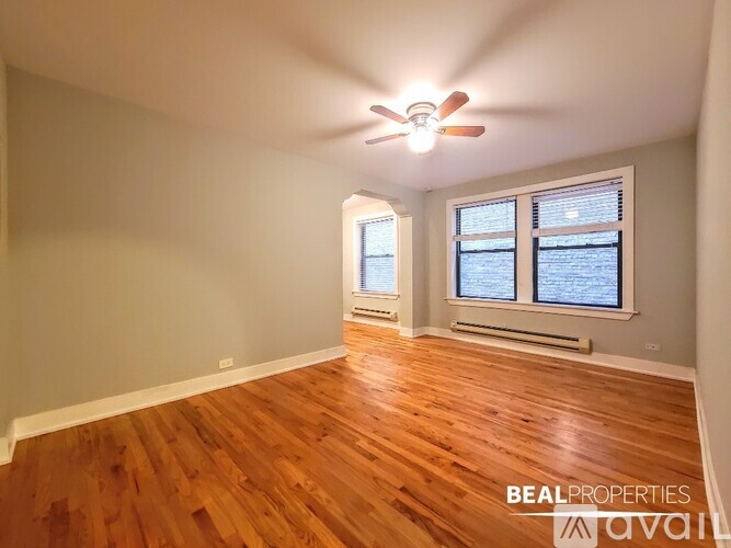 A room with wooden flooring and a ceiling fan.