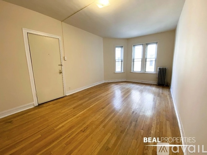 A room with wooden flooring and a white door.