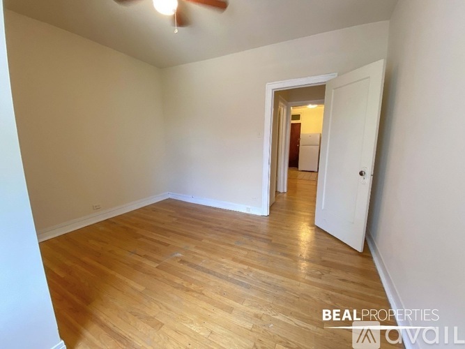 A room with wooden flooring and a ceiling fan.