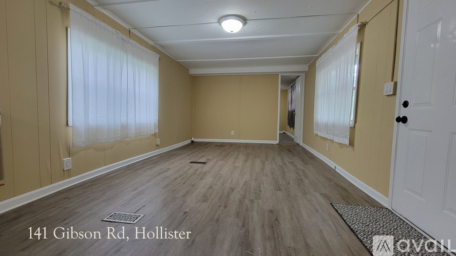 A room with wooden flooring and a white door.