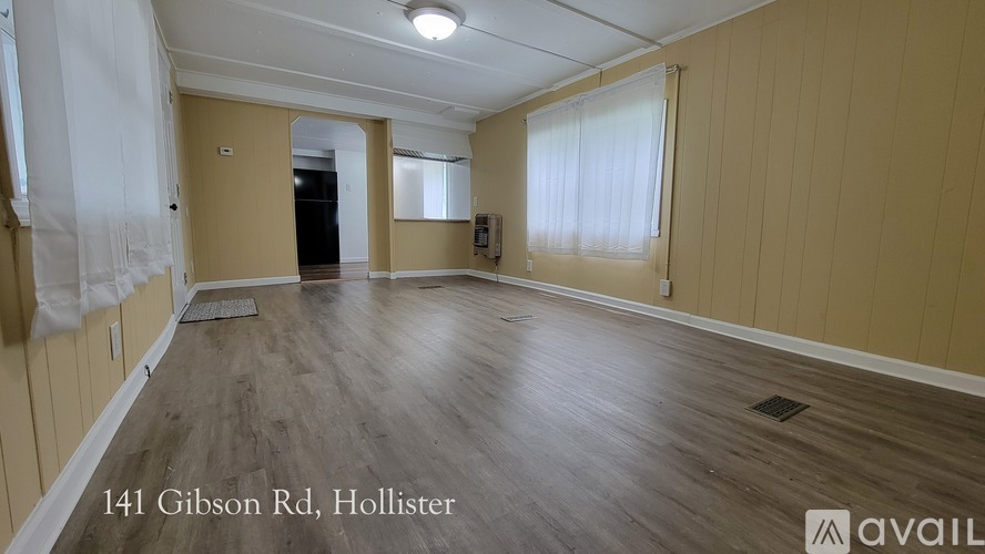 A spacious room with wooden flooring and beige walls is available for rent at 141 Gibson Rd, Hollister.