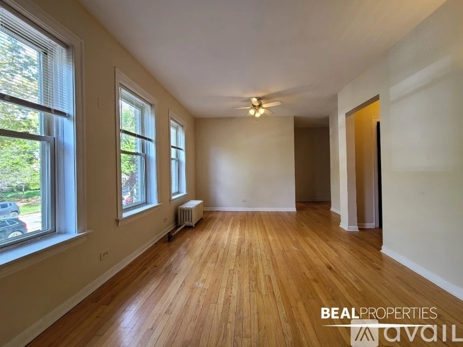 A room with wooden floors and a window on the left side.