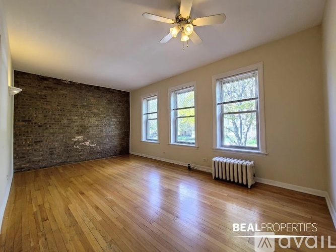 A room with a ceiling fan and wooden flooring.