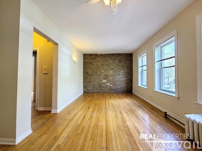A room with wooden floors and a brick wall.