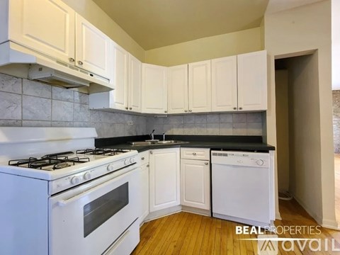 A kitchen with white cabinets and appliances.