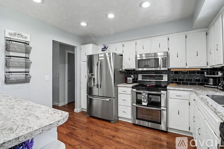 A kitchen with white cabinets and a granite counter top.