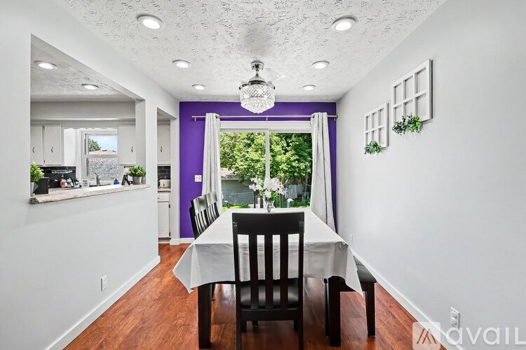 A dining room with a table and chairs.