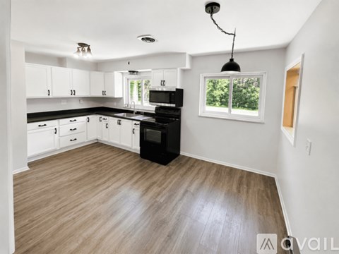 A kitchen with white cabinets and a black stove top oven.