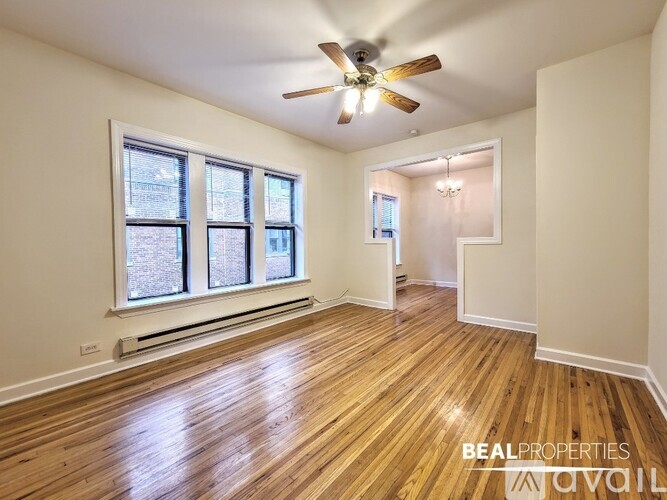 A room with wooden floors and a ceiling fan.