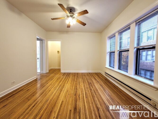 A room with wooden floors and a ceiling fan.
