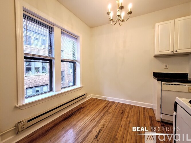 A room with wooden floors and a window overlooking a building.