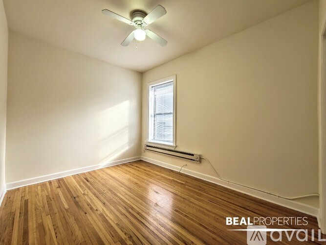 A room with a ceiling fan and wooden flooring.