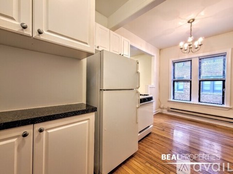 A kitchen with white cabinets and a white refrigerator.