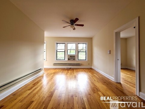 A room with wooden floors and a ceiling fan.