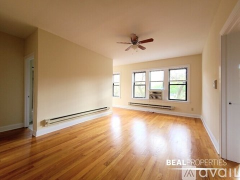 A room with wooden floors and a ceiling fan.