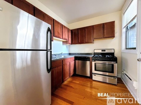 A kitchen with wooden cabinets and a stainless steel refrigerator.