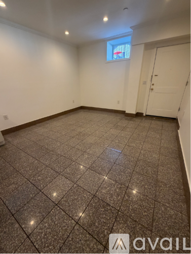 A room with a tiled floor and a window with a view of a red and white striped building.