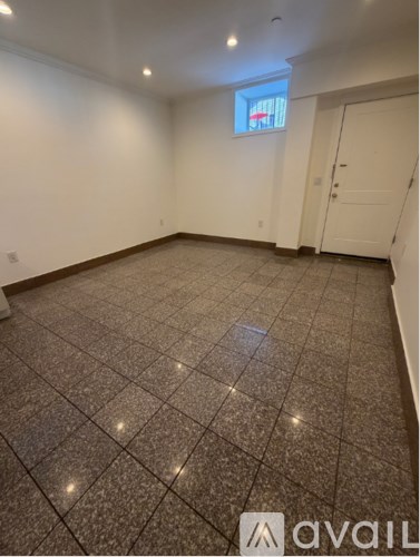 A room with a tiled floor and a window with a view of a red and white striped building.