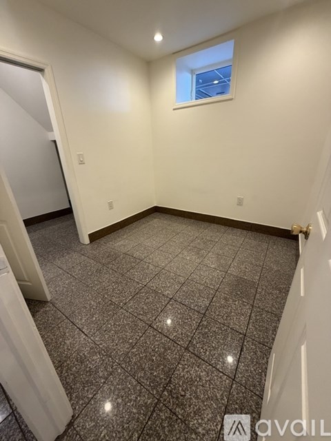 A room with a tiled floor and a small window.
