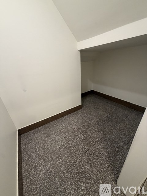 A room with a carpeted floor and white walls.