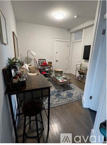 A room with a bar stool and a table with a plant on it.