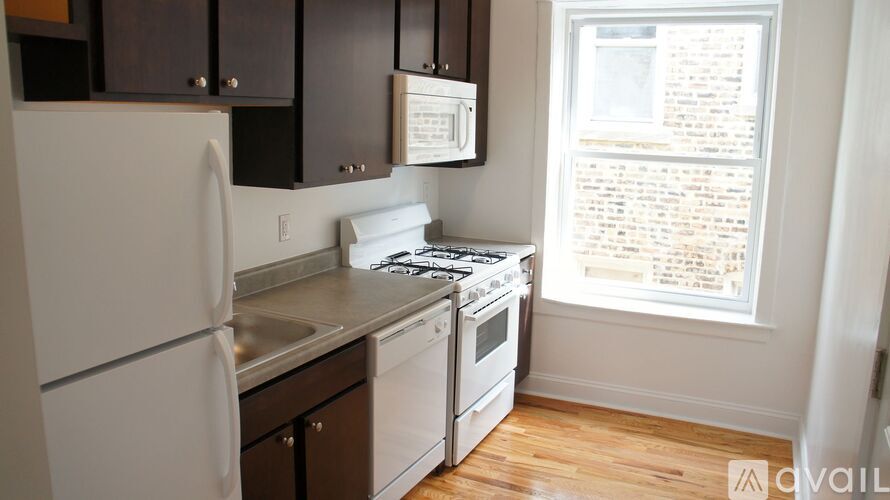 A kitchen with white appliances and wooden floors.