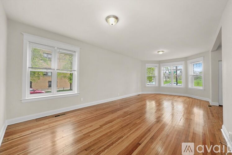 A room with wooden flooring and a large window.