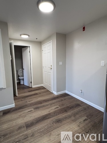 A hallway with wood flooring and white walls.