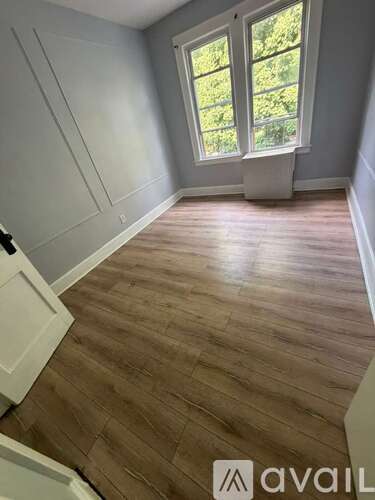 A room with wooden flooring and a window.