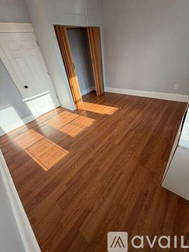 A room with wooden flooring and a white door.