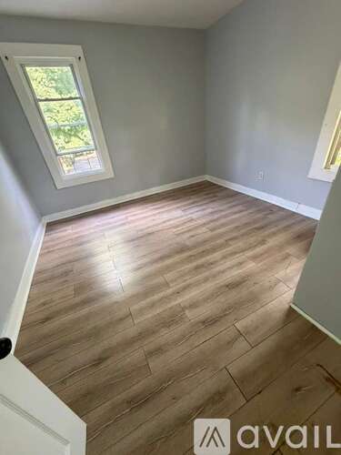 A room with wooden flooring and a window.