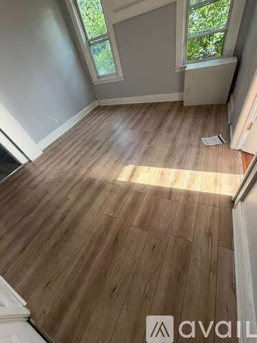 A room with wooden flooring and a window.