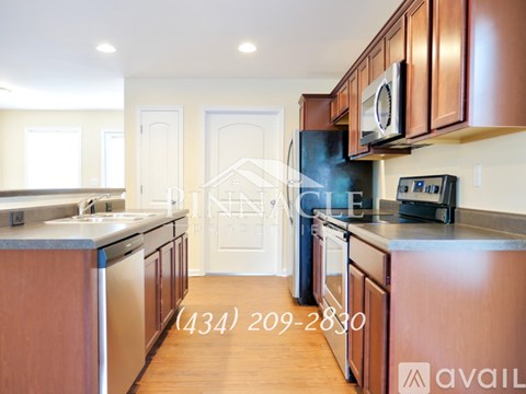 A kitchen with brown cabinets and a white door in the background.