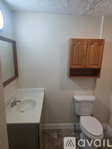 A bathroom with a toilet, sink, and medicine cabinet.