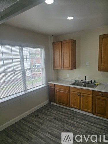 A kitchen with wooden cabinets and a sink under a window.