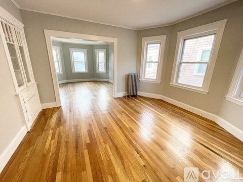 A room with wooden flooring and white walls.