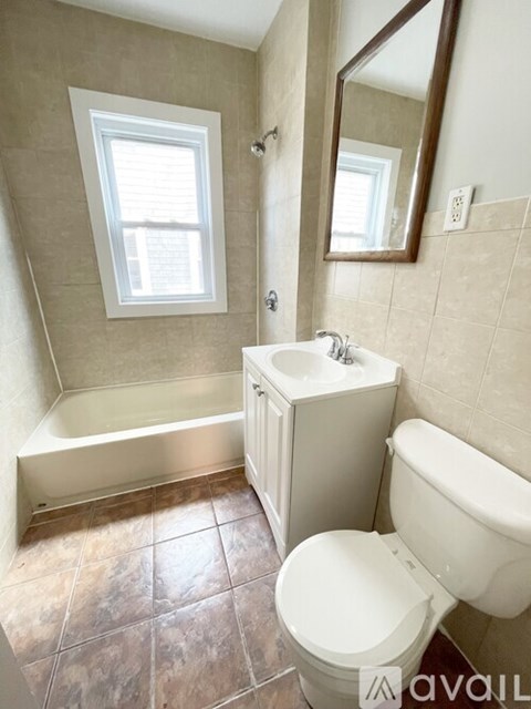 A bathroom with a toilet, sink, and bathtub.