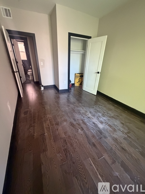 A hallway with wooden floors and two doors.