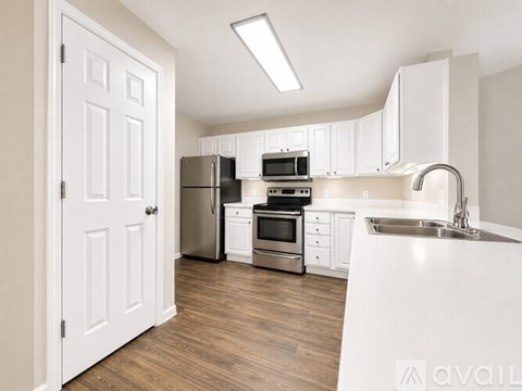 A kitchen with white cabinets and stainless steel appliances.