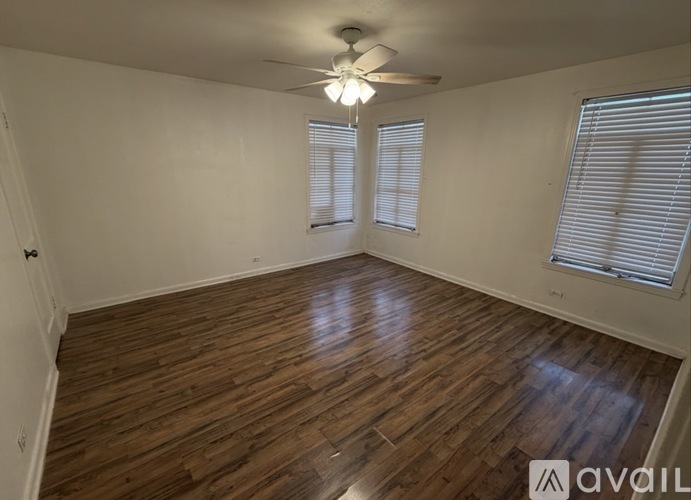 A room with wooden flooring and a ceiling fan.
