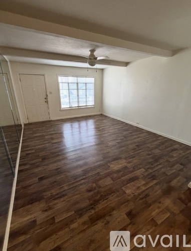 A room with wooden flooring and a window.