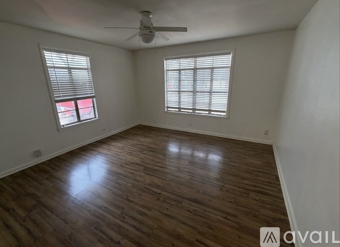 A room with wooden flooring and a ceiling fan.