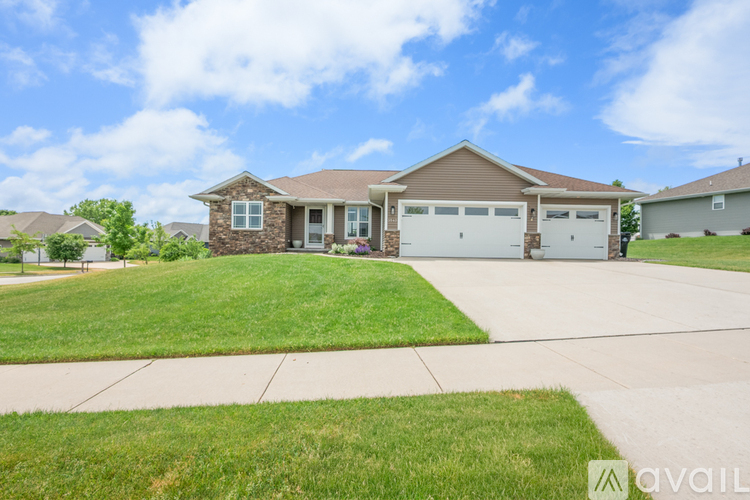 A house with a brown roof and a garage door is in front of a grassy area.