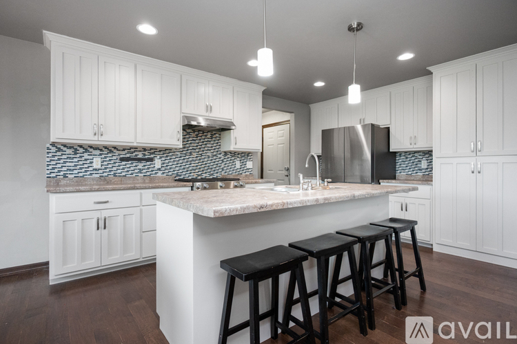 A kitchen with white cabinets and a marble countertop.