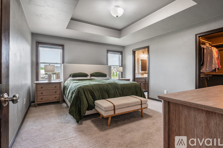 A bedroom with a bed, dresser, and mirror.
